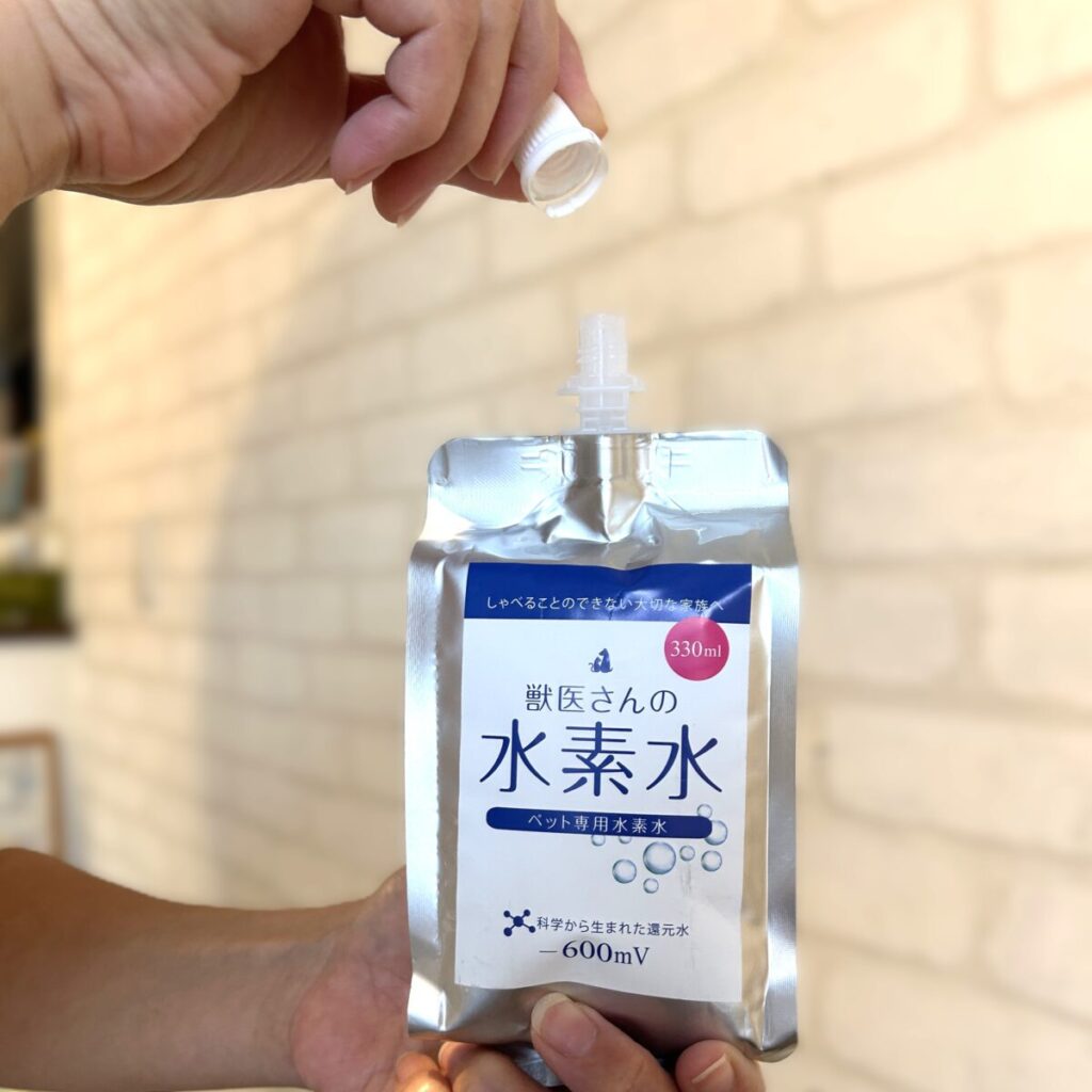 「獣医さんの水素水」のキャップを開けている様子。特許技術で水素が抜けにくく、開封後も高濃度をキープできる。